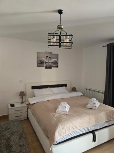 a bedroom with a large bed and a chandelier at ARIJA studio apartment in Žabljak