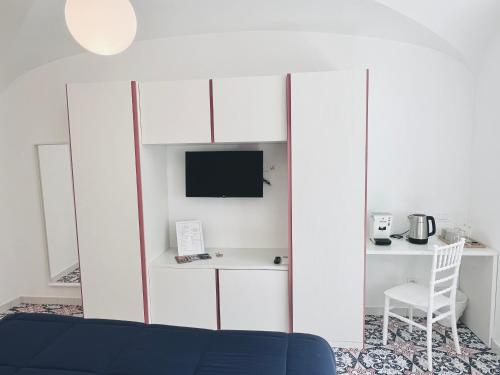 sala de estar con armario blanco y escritorio en A Gradillo holiday rooms, en Ravello