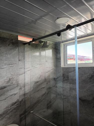 ein Bad mit einer Glasdusche und einem Fenster in der Unterkunft Finca La Macarena by Welttisch in Génova