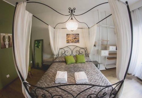 ローマにあるVerrazzano 37 Guest Houseのベッドルーム(緑の枕と天蓋付きベッド付)