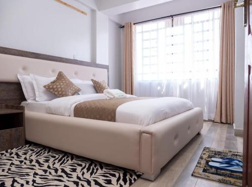 a bedroom with a large bed and a zebra rug at snazzy guest house in Nakuru