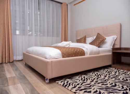 a bedroom with a large bed with a zebra rug at snazzy guest house in Nakuru