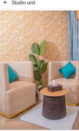 a living room with two chairs and a table at snazzy guest house in Nakuru