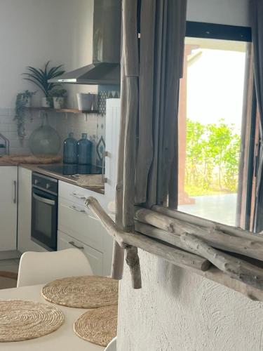 a kitchen with a table with chairs and a window at Favone Mini Villa Playa del Oro in Favone