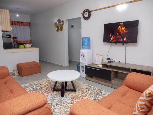 sala de estar con 2 sofás y chimenea en snazzy guest house, en Nakuru
