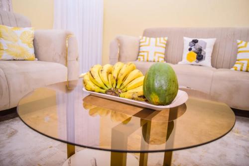 a table with a plate of bananas and a melon at snazzy guest house in Nakuru