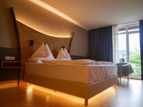 Schlafzimmer mit einem großen Bett mit einem Kopfteil aus Holz in der Unterkunft Weinresidenz Sonnleitner - ADULTS ONLY in Furth
