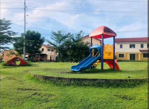 a playground with a slide in the grass at tadzmahal home in Pagadian