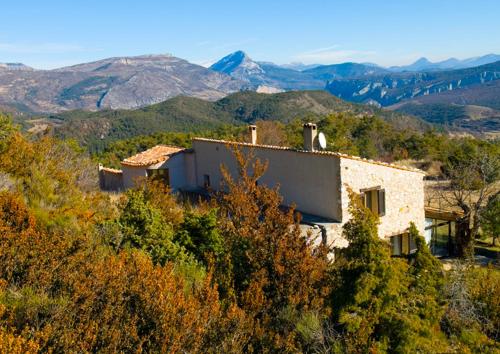 a house on a hill with mountains in the background at LPSV Experience B&B in La Palud sur Verdon in La Palud-sur-Verdon
