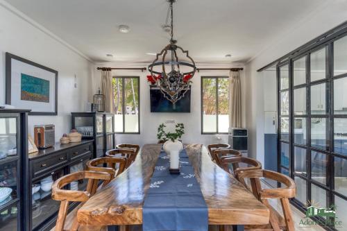 Adora's Place في كورون: غرفة طعام مع طاولة وكراسي خشبية كبيرة