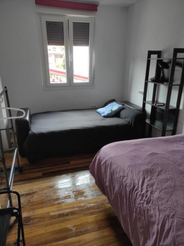 a room with a bed and a couch and two windows at Begogane in Santurce