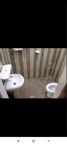 een badkamer met een wastafel en een toilet. bij Au Havre de Paix in Niamey