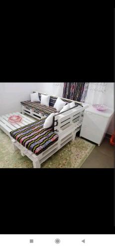 een kamer met 2 bedden met kussens erop bij Au Havre de Paix in Niamey