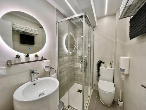 uma casa de banho branca com um lavatório e um chuveiro em Dávila HOME Beach em Santander
