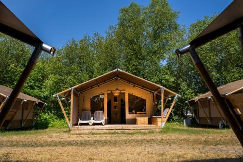 a tent with two chairs in front of it at Safaritent de Windroos in Kamperland