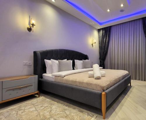 a bedroom with a large bed with a black headboard at Xəzər İstirahət Mərkəzi in Bunud