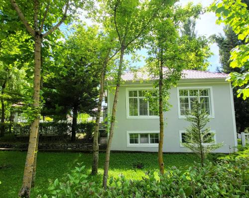 a white house with trees in front of it at Xəzər İstirahət Mərkəzi in Bunud
