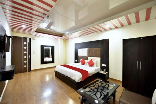 a bedroom with a large bed and a television at Goroomgo Hotel Dalhousie Grand Banikhet Near Mata Jawala Temple - Luxury Stay - Excellent Service - Parking Facilities in Banikhet
