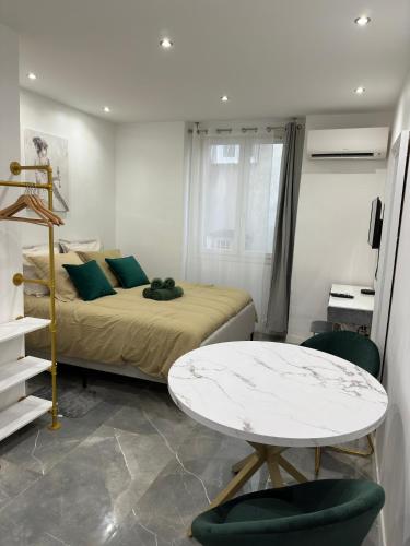 une chambre avec un lit, une table et des chaises dans l'établissement La Chic Opéra NETFLIX/WIFI, à Marseille