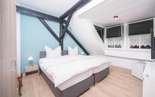 a bedroom with a large bed with white sheets at Hotel Café am Stift in Hessisch Oldendorf