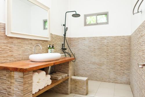 um banheiro com pia e chuveiro em Seapearl of Alona em Panglao City
