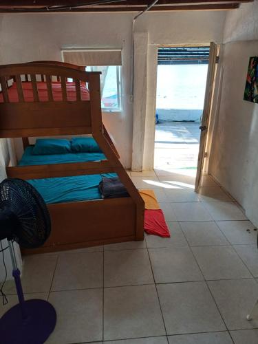 a bedroom with a bunk bed on a tiled floor at Cabaña La Punta in Isla Grande