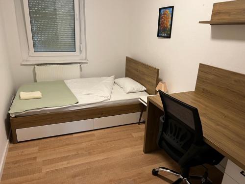 1 dormitorio con cama, escritorio y silla en Stuttgart-Mitte en Stuttgart