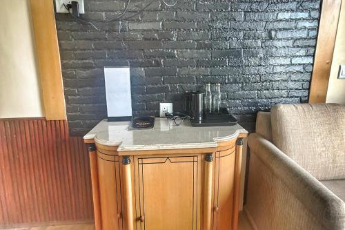 a counter with a coffee maker on it next to a brick wall at Hari Om Paradise in Kūfrī