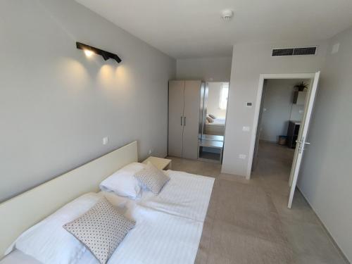 a bedroom with a bed with white sheets and pillows at Villa Badi in Umag
