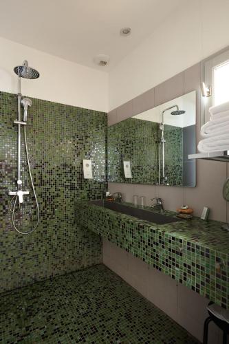a bathroom with a shower and a sink and a mirror at Boutique Hôtel Entraigues in Uzès