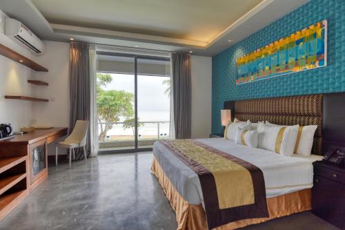 Schlafzimmer mit einem Bett, einem Schreibtisch und einem Fenster in der Unterkunft Golden Pearl Tangalle Beach New in Hambantota