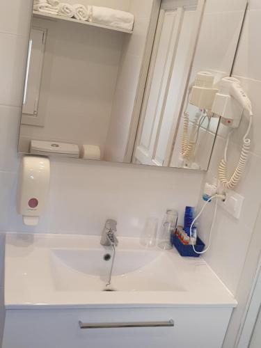 a white bathroom with a sink and a mirror at Hostal Mi Campaña in Denia