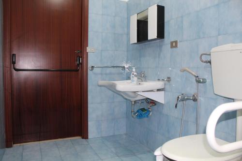 y baño con aseo y lavamanos. en Villa Nastasi, en San Pier Niceto
