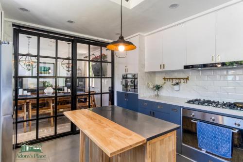 a kitchen with blue cabinets and a wooden counter top at Adora's Place - Premium Room in Coron