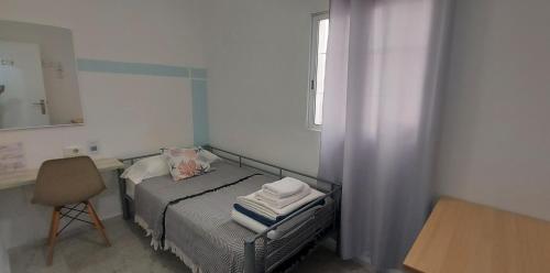 a small bedroom with a bed and a chair at Coordenadas Ibiza in Ibiza Town