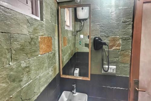 a bathroom with a urinal and a phone on the wall at Hari Om Paradise in Kūfrī