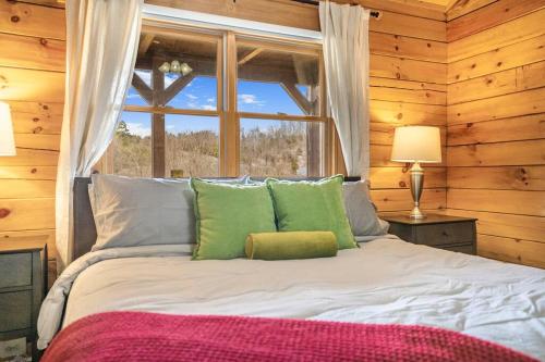 un letto con cuscini verdi in una stanza con finestra di Balk Oasis, Mountain Views,Rustic, HotTub a Stanley