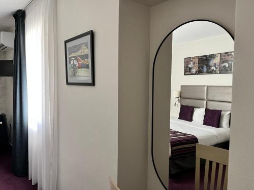 Irin Hotel في أنتيب: غرفة نوم مع مرآة وسرير