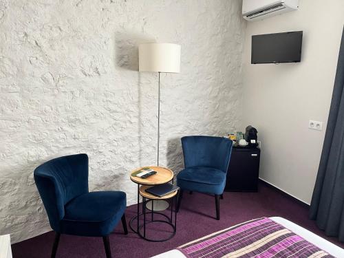 een kamer met 2 stoelen, een tafel en een tv bij Irin Hotel in Antibes