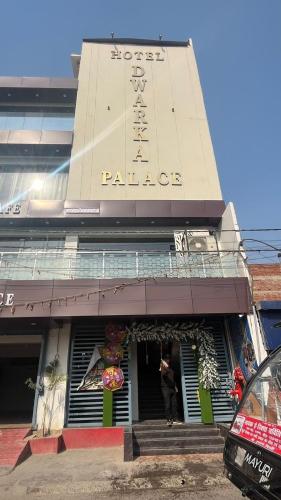Hotel dwarka palace في Darbhanga: رجل واقف عند مدخل المبنى