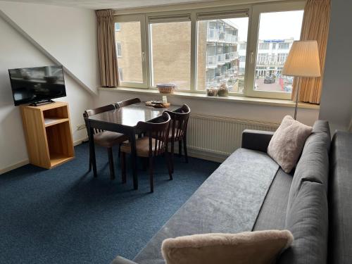 a living room with a couch and a table at Hotel Noordzee in Zandvoort