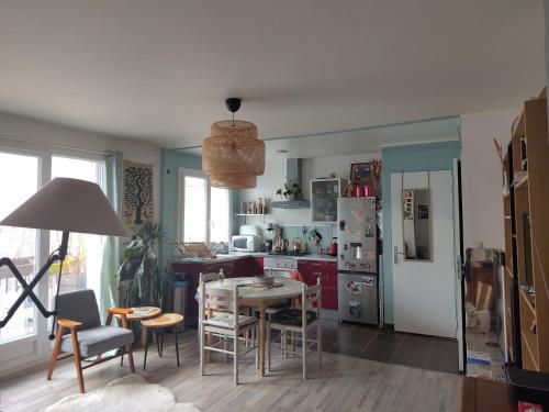 une cuisine avec une table, des chaises et un réfrigérateur dans l'établissement T2 proche ligne 14 Kremlin Bicêtre, au Kremlin-Bicêtre