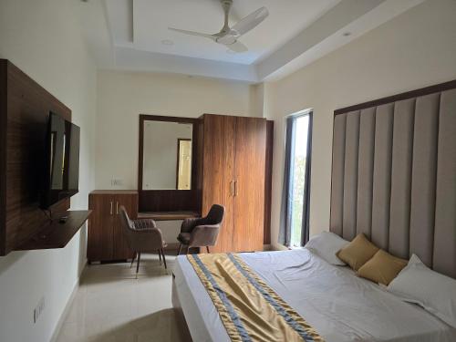 een slaapkamer met een bed, een bureau en een televisie bij MBS BANQUETS in Amritsar