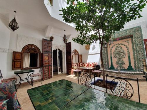 sala de estar con mesa y árbol en Riad Alma Mouassine en Marrakech