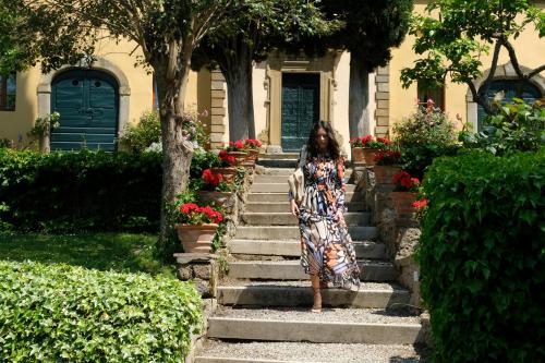 a woman in a dress standing on some stairs at Il Falconiere Relais & Spa in Cortona