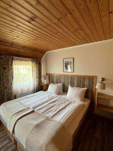 Drei Jahreszeiten في Bredsatra: سرير كبير في غرفة ذات سقف خشبي