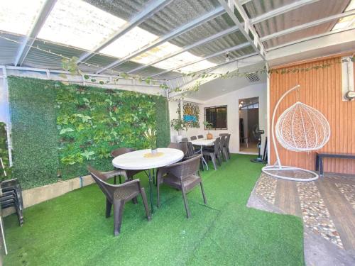 a room with a table and chairs and a green wall at Casa S Ocampo in Canlalay