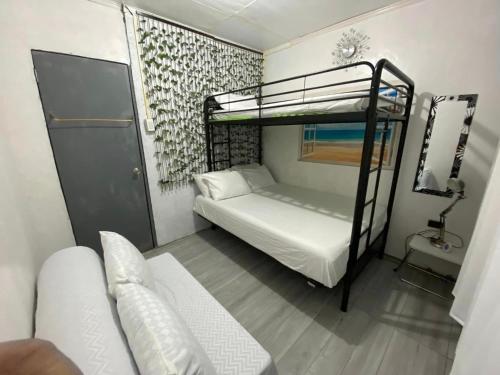 a bedroom with two bunk beds and a couch at Casa S Ocampo in Canlalay