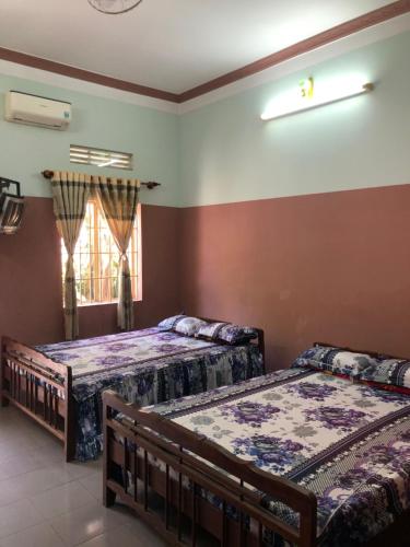 - une chambre avec 2 lits et une fenêtre dans l'établissement Nhà nghỉ Mỹ Hà, à Thôn Khánh Cam