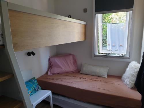 Etagenbett in einem kleinen Zimmer mit Fenster in der Unterkunft Mobilhome Grand confort 6 à 8 personnes in Sainte-Marie-de-Ré